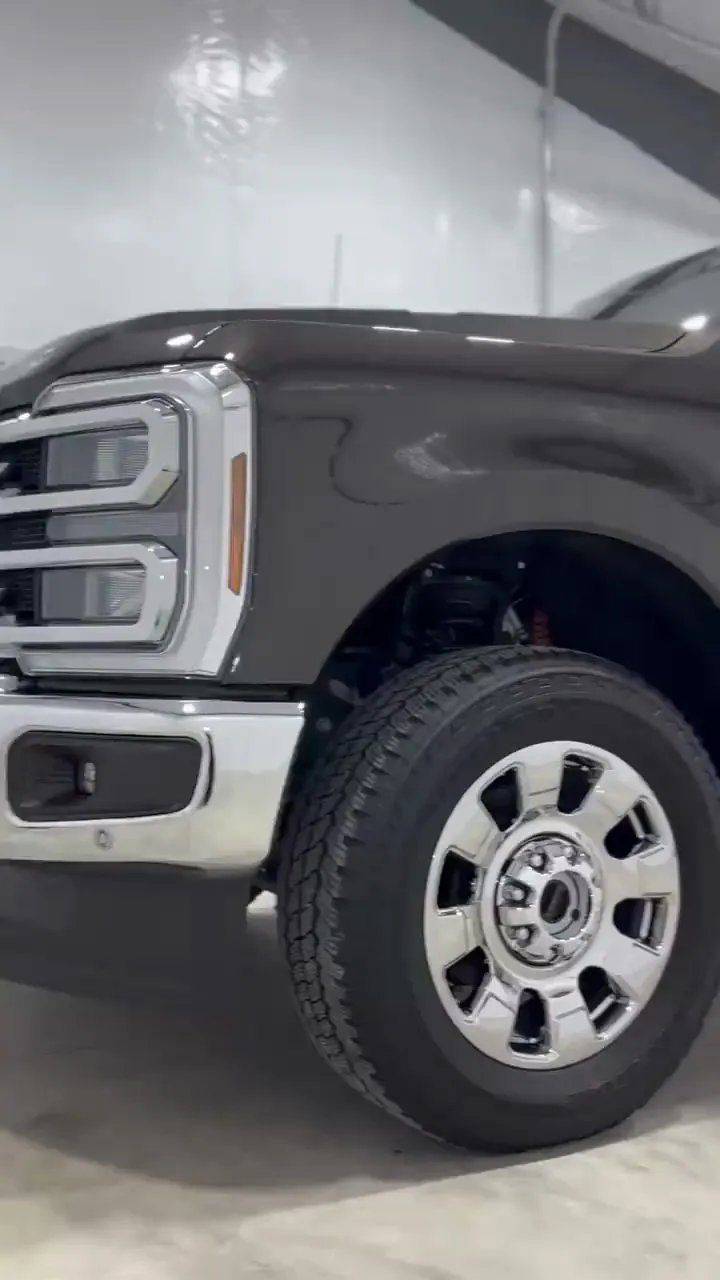 Dark gray Ford F-250 with glossy paint and polished wheels in the Hermsmeyer Detailing shop